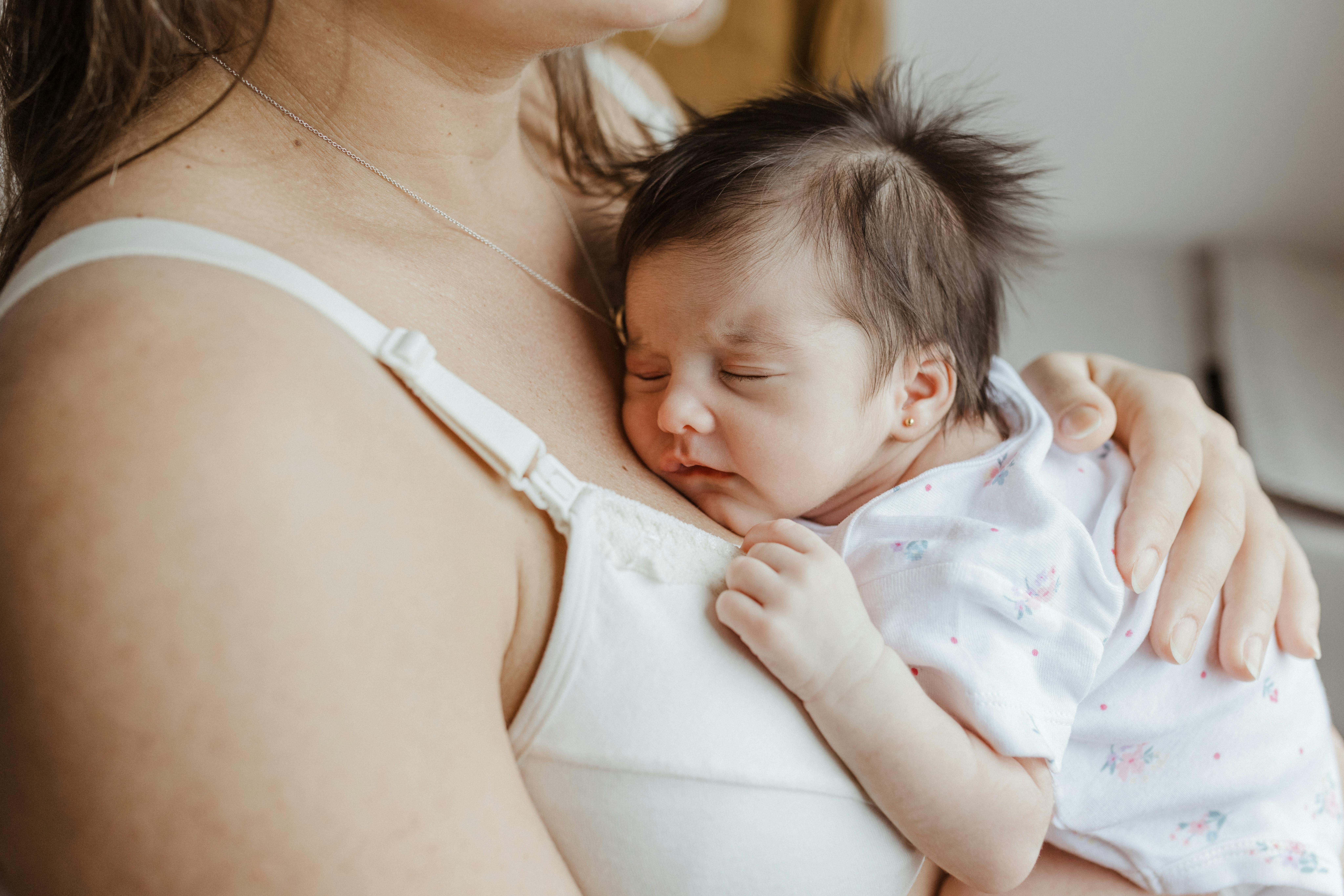 A newborn resting skin to skin on a parent's chest