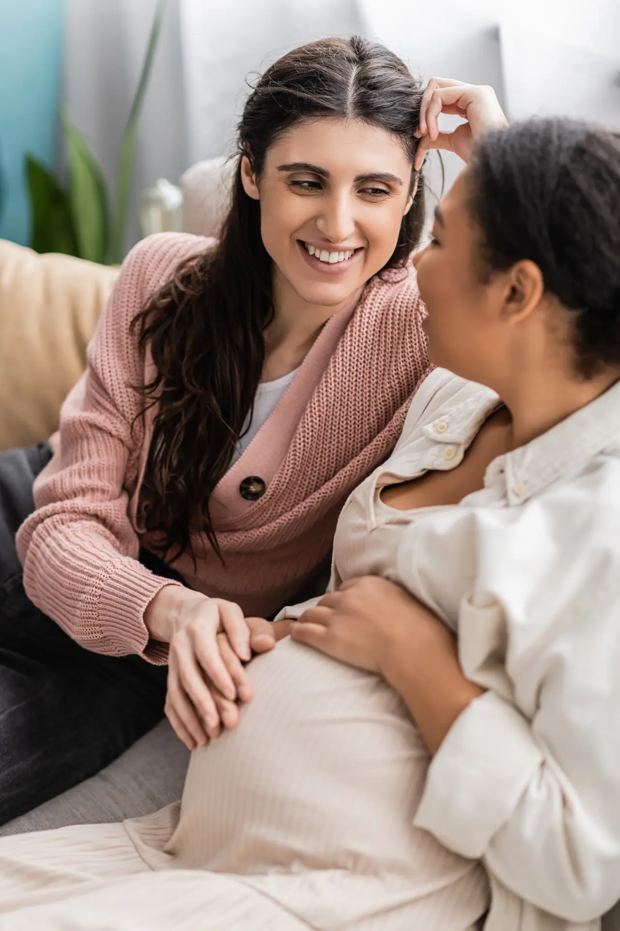 An expectant mother talking with a friend at home