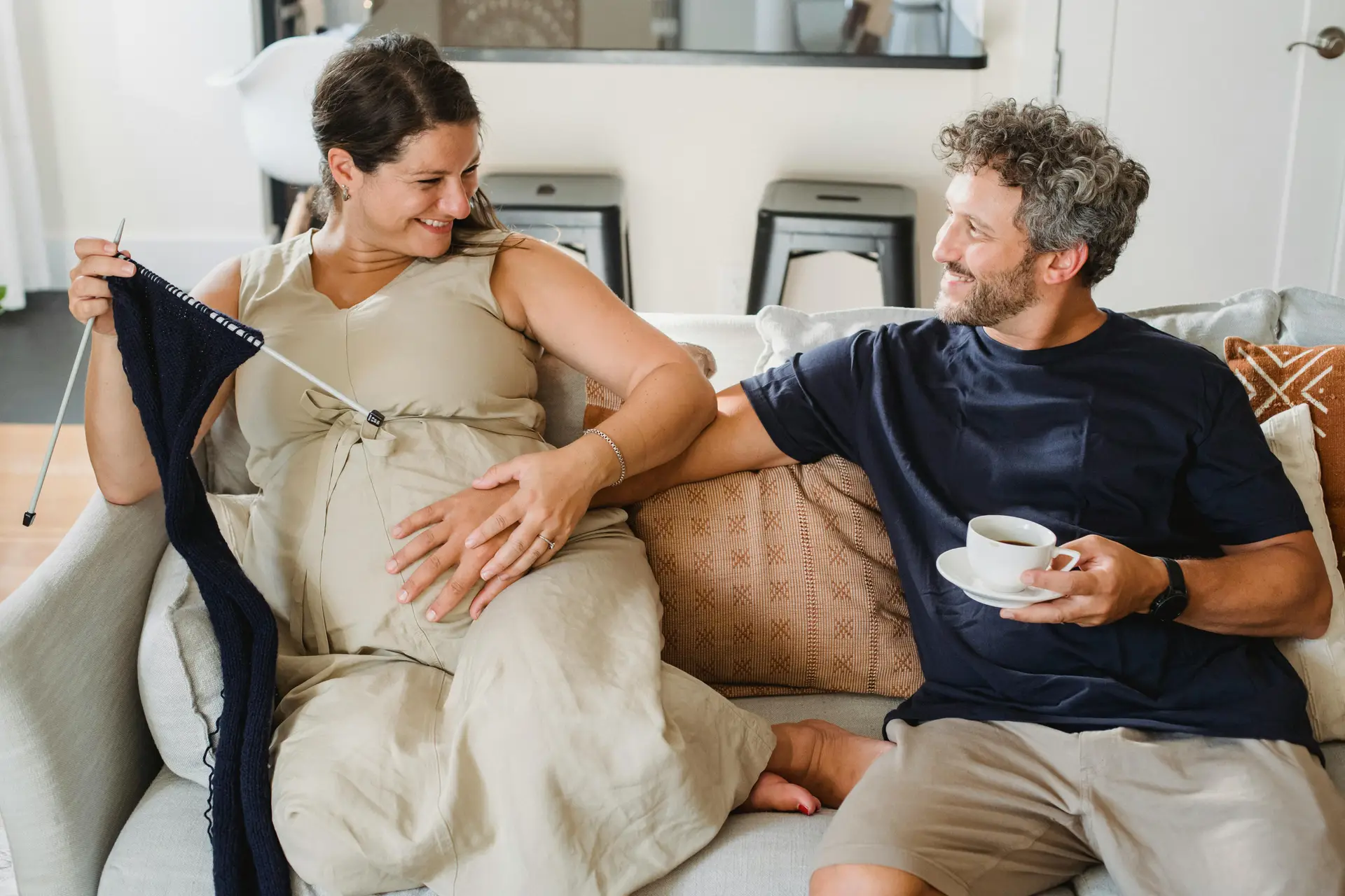 An expectant couple relaxing together on the couch